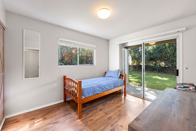 bedroom featuring hardwood / wood-style flooring and access to outside