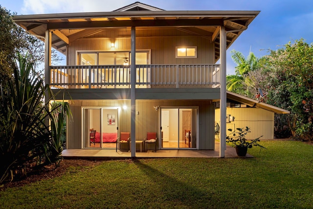 back of house featuring a yard, a balcony, and a patio