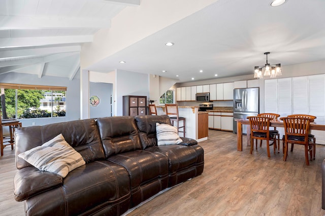 living room with vaulted ceiling with beams, light hardwood / wood-style floors, and a notable chandelier