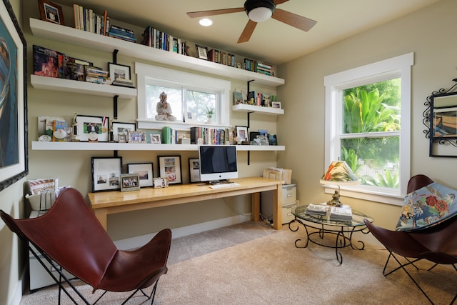 office featuring light carpet, built in desk, and ceiling fan