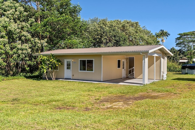 rear view of property featuring a yard