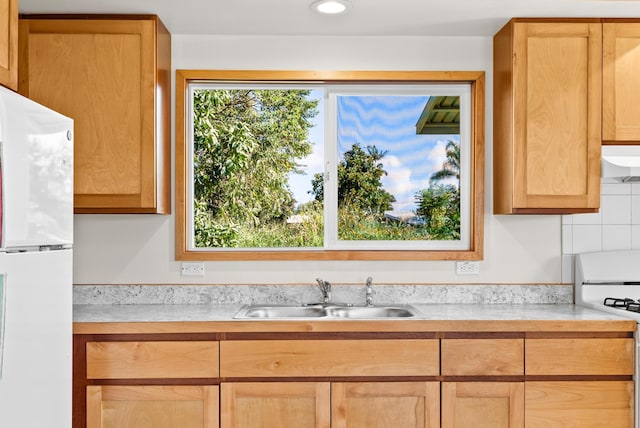 kitchen featuring white appliances, sink, and extractor fan