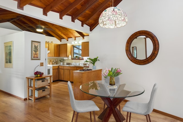 dining room featuring light hardwood / wood-style flooring, beamed ceiling, high vaulted ceiling, and wood ceiling