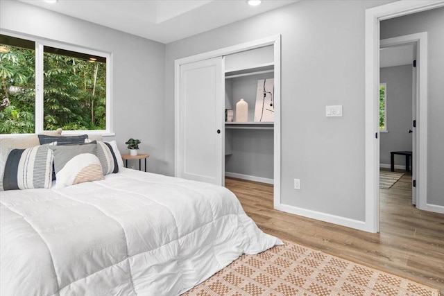 bedroom with light hardwood / wood-style flooring and a closet