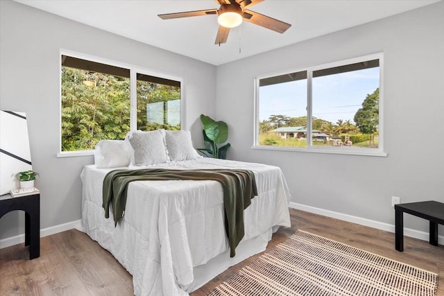 bedroom featuring multiple windows, ceiling fan, and hardwood / wood-style flooring