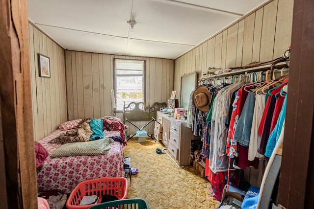 carpeted bedroom featuring wooden walls