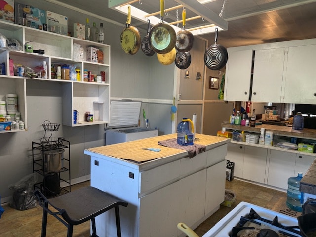 kitchen with a kitchen island and white cabinetry