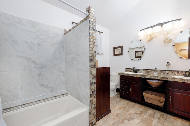 full bathroom featuring tiled shower / bath, vanity, and toilet