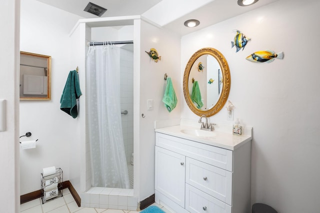 bathroom featuring tile patterned flooring, vanity, and walk in shower