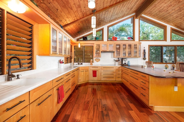 kitchen with decorative light fixtures, lofted ceiling with beams, and sink