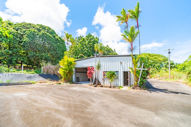 view of front of home featuring a garage and an outbuilding