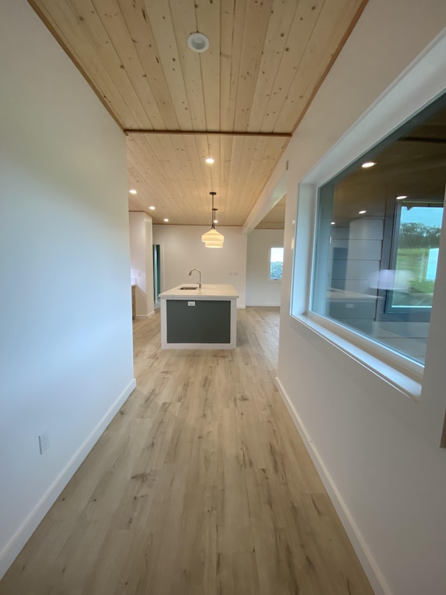 hallway featuring sink, light wood-type flooring, and wood ceiling