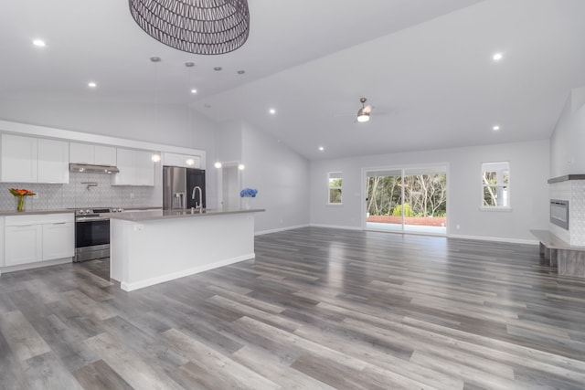 kitchen with light wood-type flooring, stainless steel appliances, ceiling fan, white cabinetry, and an island with sink