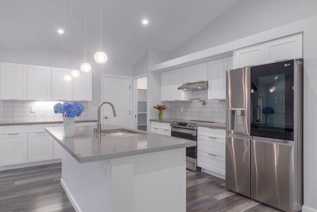 kitchen with appliances with stainless steel finishes, vaulted ceiling, sink, white cabinetry, and an island with sink