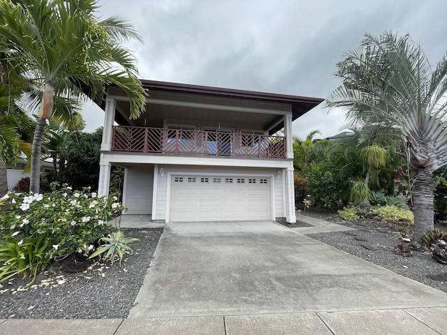 view of front facade with a garage, driveway, and a balcony