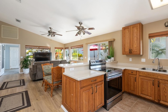 kitchen featuring stainless steel range with electric stovetop, sink, lofted ceiling, and kitchen peninsula