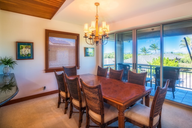 dining space with a notable chandelier, light colored carpet, and wooden ceiling