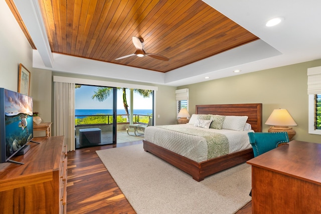 bedroom with a raised ceiling, access to exterior, ceiling fan, and dark hardwood / wood-style floors