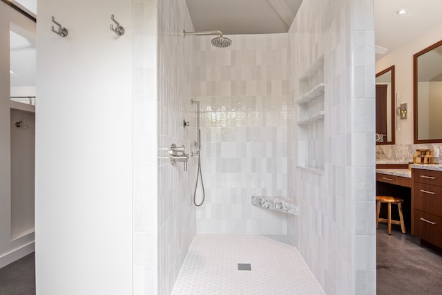 bathroom featuring a tile shower and vanity