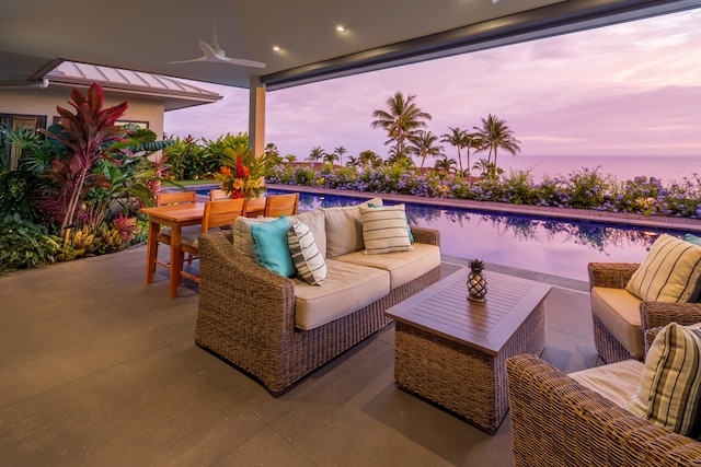 patio terrace at dusk with outdoor lounge area and ceiling fan