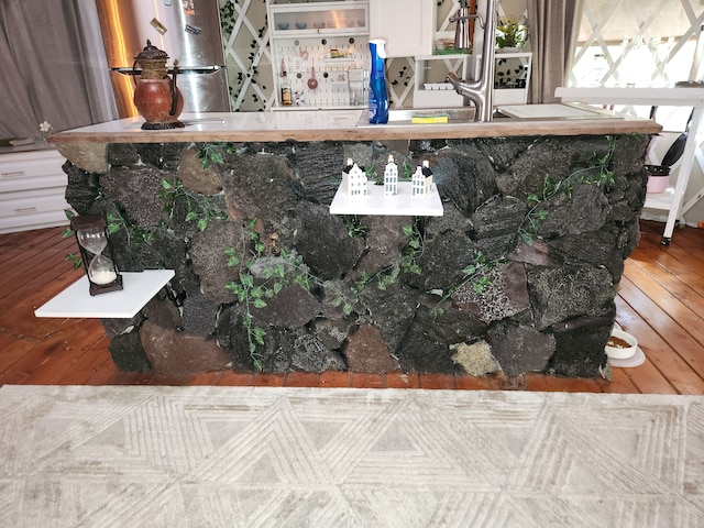 interior details featuring stainless steel fridge and wood-type flooring