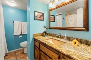 bathroom with tile patterned flooring, vanity, and toilet