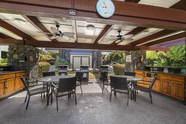 view of patio / terrace featuring ceiling fan, exterior kitchen, and grilling area