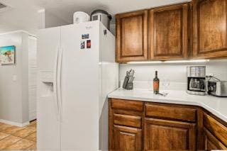 kitchen featuring light tile patterned flooring and white refrigerator with ice dispenser