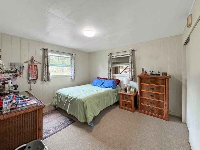 carpeted bedroom featuring wood walls