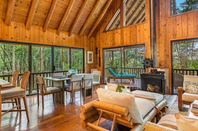 sunroom featuring vaulted ceiling with beams, wooden ceiling, and a healthy amount of sunlight