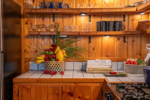 kitchen featuring stainless steel refrigerator and tile countertops