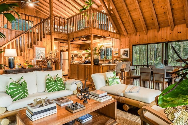 living room featuring wood walls, beamed ceiling, high vaulted ceiling, and wood ceiling