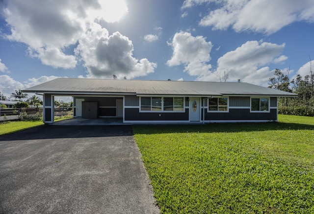 ranch-style home featuring a carport and a front lawn