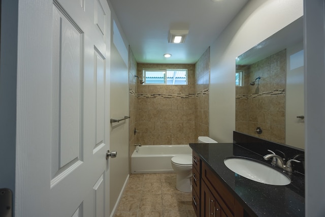 full bathroom featuring tiled shower / bath combo, toilet, and vanity