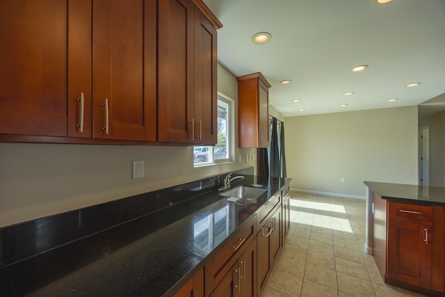 kitchen featuring light tile patterned flooring, sink, and dark stone counters