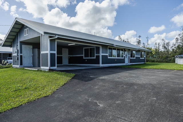 view of front of house with a carport and a front yard