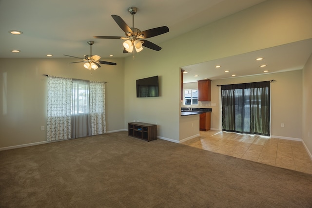 unfurnished living room featuring ceiling fan and light colored carpet