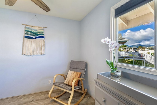 sitting room with hardwood / wood-style floors and ceiling fan