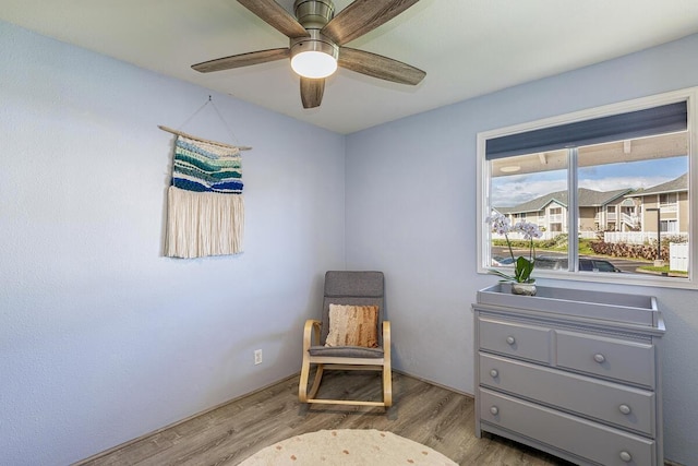 sitting room with ceiling fan and light wood-type flooring