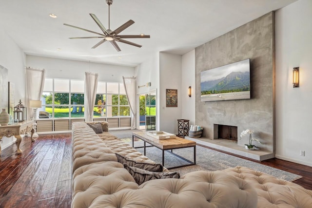 living room with a fireplace, wood-type flooring, and ceiling fan