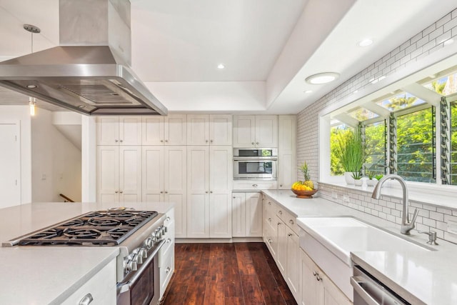 kitchen featuring sink, stainless steel appliances, dark wood-type flooring, tasteful backsplash, and extractor fan