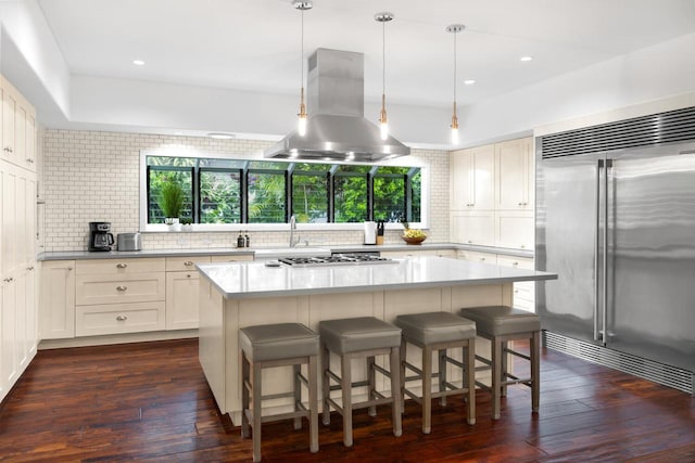 kitchen featuring island exhaust hood, dark hardwood / wood-style flooring, a center island, and appliances with stainless steel finishes