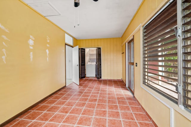 hallway featuring washer / clothes dryer and wood walls