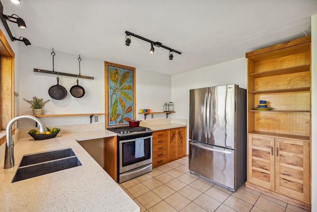 kitchen with light stone countertops, appliances with stainless steel finishes, light tile patterned floors, and sink