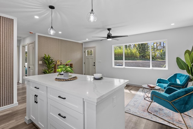 kitchen featuring a center island, white cabinets, hanging light fixtures, ceiling fan, and light hardwood / wood-style floors