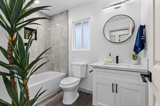 full bathroom with vanity, wood-type flooring, tiled shower / bath combo, and toilet