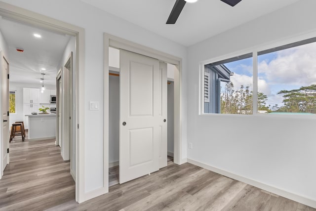 unfurnished bedroom with ceiling fan, a closet, and light hardwood / wood-style flooring