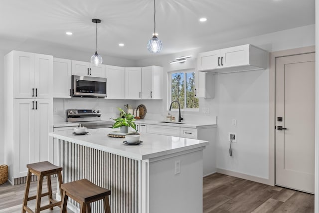 kitchen with white cabinetry, a center island, pendant lighting, and appliances with stainless steel finishes