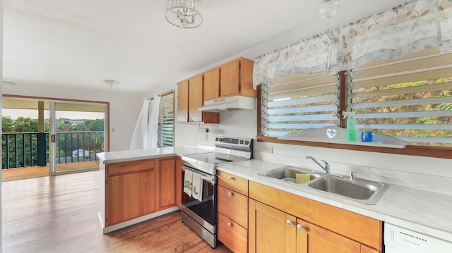 kitchen with stainless steel electric range, dishwasher, sink, light hardwood / wood-style flooring, and kitchen peninsula