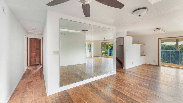 spare room with a wealth of natural light, ceiling fan, and hardwood / wood-style flooring